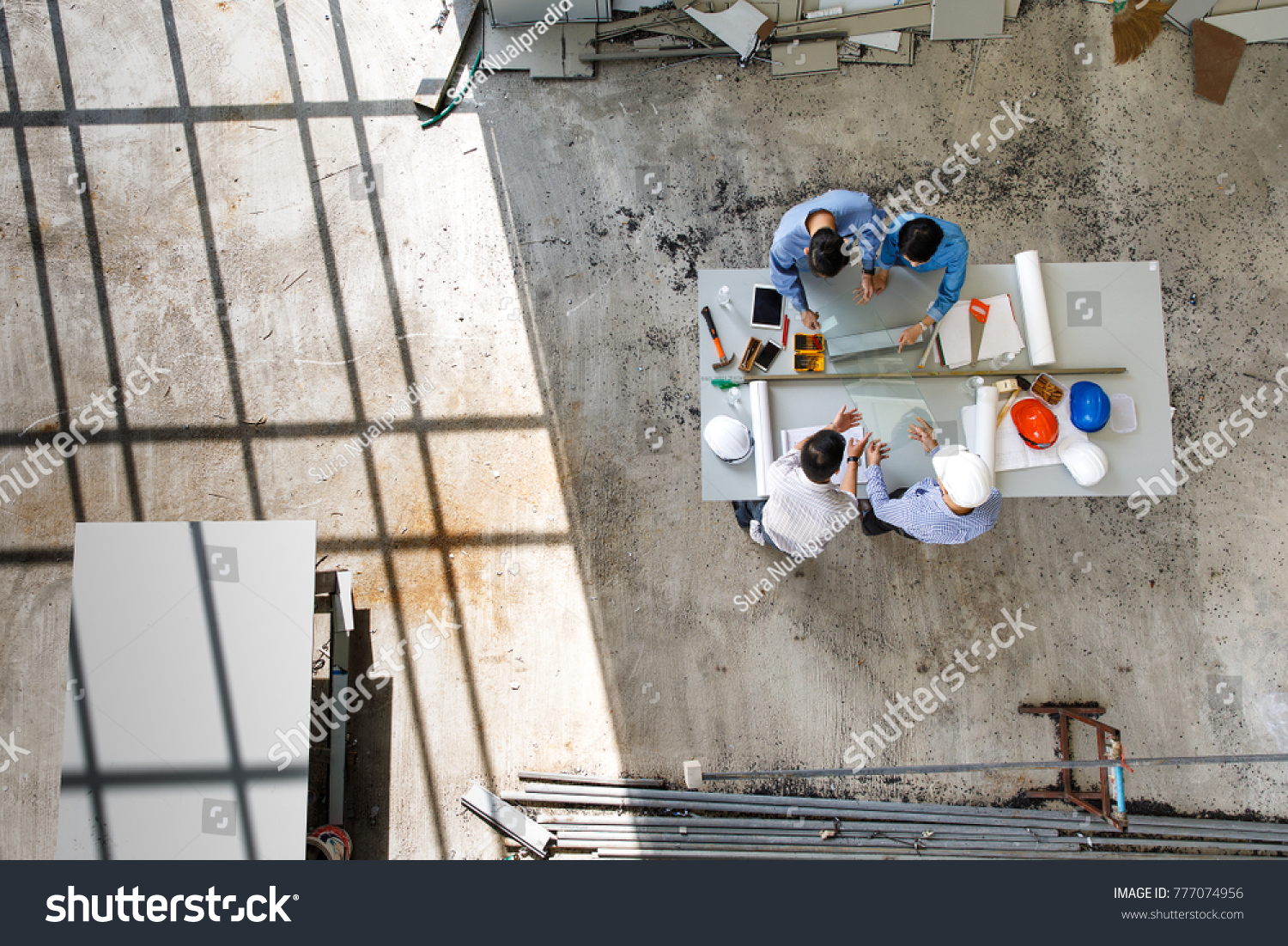 stock-photo-four-engineers-in-team-making-a-discussion-at-construction-site-with-several-color-helmets-taken-777074956